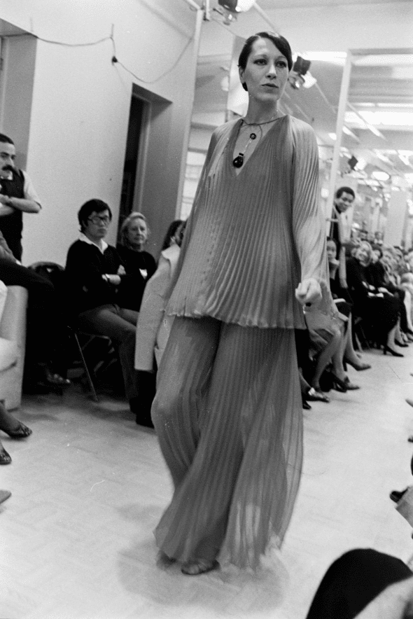 Model Elsa Peretti walks in Halston’s spring 1974 made-to-order collection show, wearing her silver and black jade bottle necklace, 1973. Model Elsa Peretti walks in Halston’s spring 1974 made-to-order collection show, wearing her silver and black jade bottle necklace, 1973.